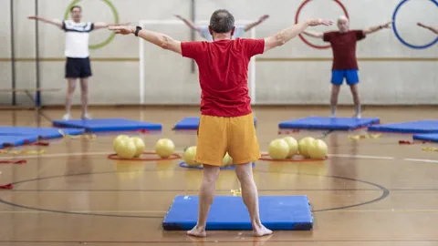 Menschen machen Übungen in einem Fitnessstudio.