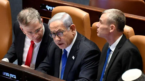 Benjamin Netanjahu, umringt von zwei Ministern, im israelischen Parlament