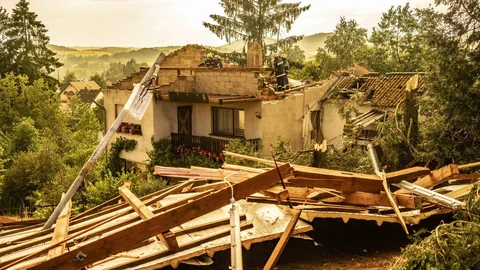 Rettungskräfte arbeiten in der deutschen Gemeinde Freisen an einem zerstörten Haus.