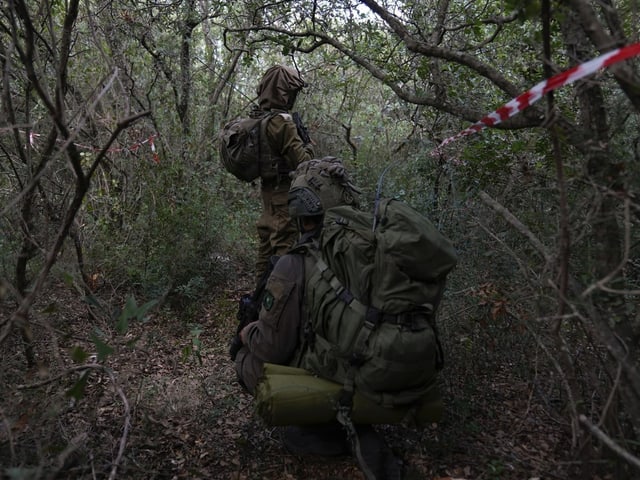 Israelische Soldaten im Tarnanzug verstecken sich in Büschen. 