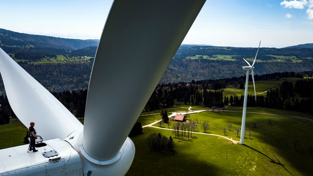 Ein Mann steht auf einer Windturbine auf dem Mont-Soleil.