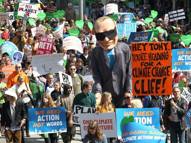 Hunderte von Demonstranten mit Transparanten. Darunter auch eine übergrosse Puppe, die Tony Abbott darstellt. 