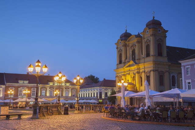 Im Dämmerlicht sieht man die Kathedrale St. Georg und auf dem Platz ein paar Strassencafés.