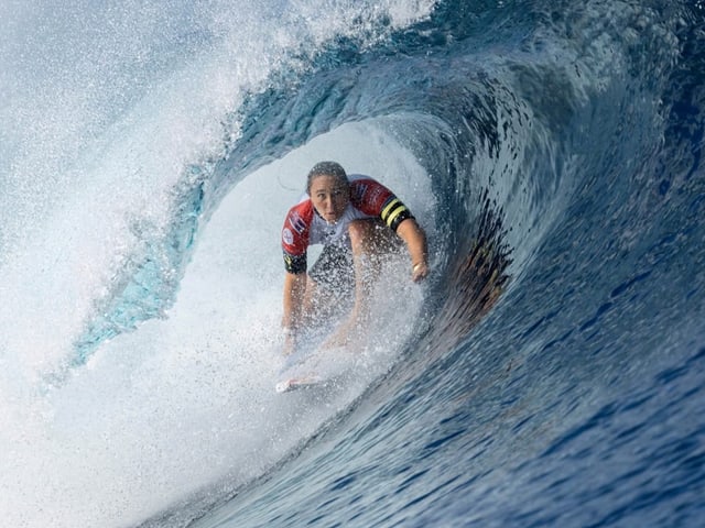 Surferin in einer grossen brechenden Welle.