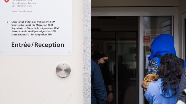 Menschen betreten ein Bundesasylzentrum. Zu sehen ist die Beschriftung des Gebäudes.