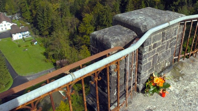 Blumen erinnern an einen Menschen, der von dieser Brücke in den Tod gesprungen ist.