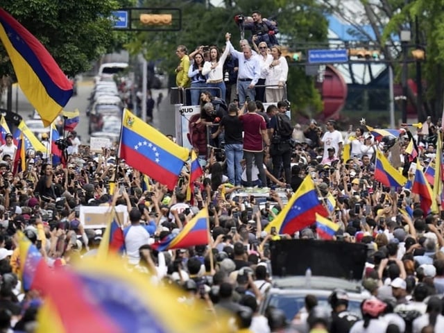 Menge von Menschen bei einer Demonstration mit venezolanischen Flaggen.