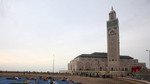 Menschen versammeln sich vor der Hassan II Moschee in Casablanca 