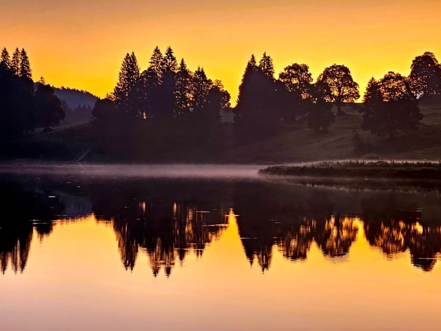 Farbige Dämmerung spiegelt sich im See