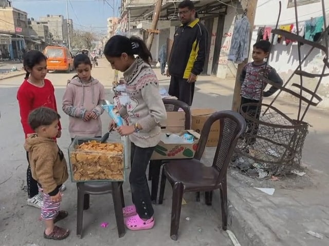 Das Mädchen verkauft anderen Kindern Chips. 