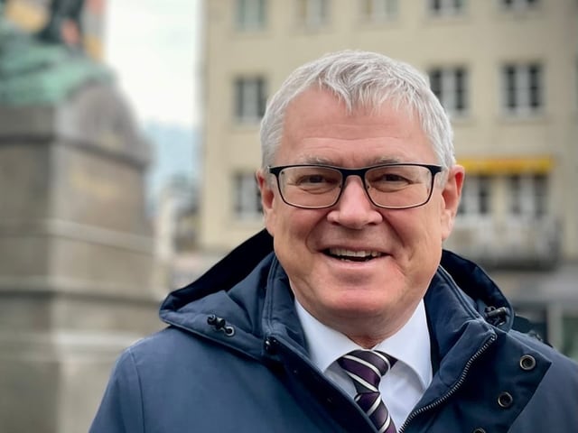 Ein Mann mit grauem Haar und Brille.