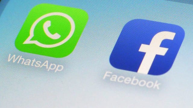 Logo von Whatsapp und das von Facebook auf einem Display