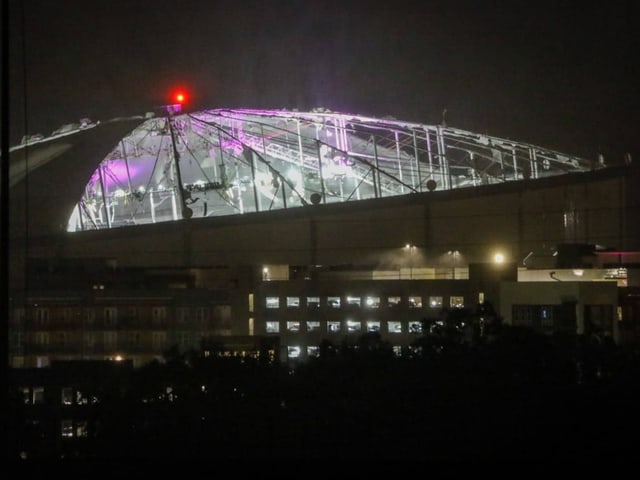 Beleuchtetes Stadiondach bei Nacht.