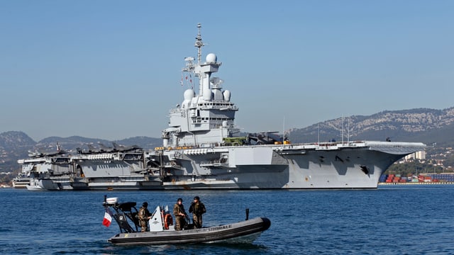 Der französische Flugzeugträger Charles de Gaulle, davor ein Schlauchboot.