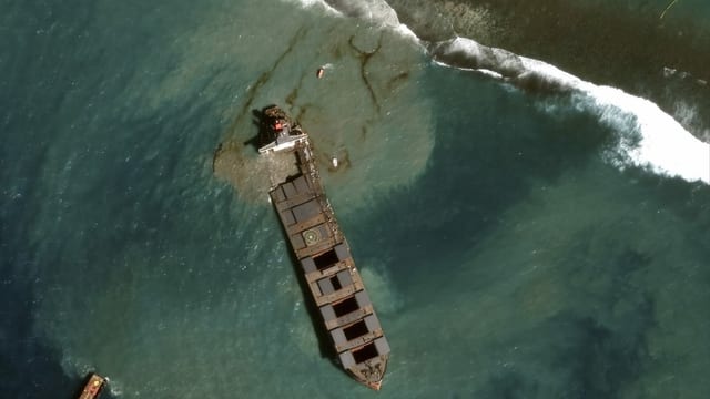 Der Frachter ist von oben zu sehen, Öl läuft ins Meer.