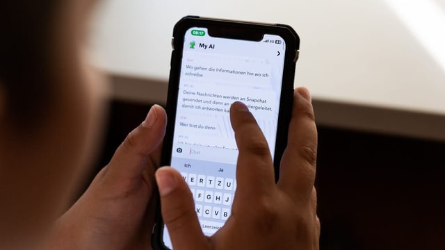 Kind schreibt auf dem Handy mit Snapchat «My AI»