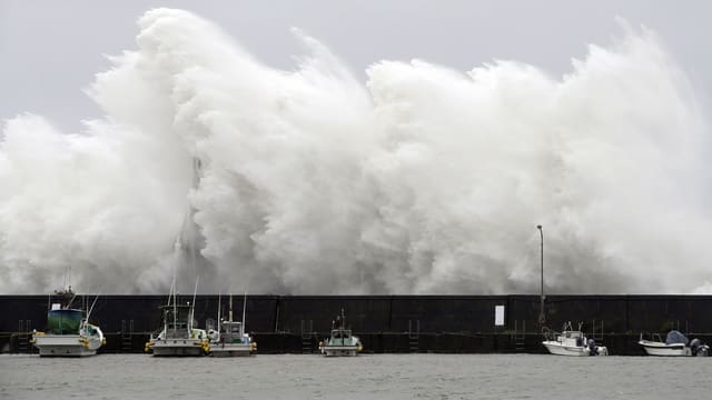 Eine Welle trifft auf den Hafen im japanischen Aki.