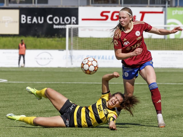 Zwei Fussballspielerinnen im Wettkampf um den Ball auf dem Spielfeld.