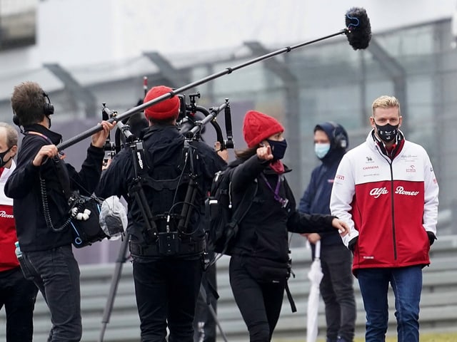 Mick Schumacher (right) is besieged by reporters