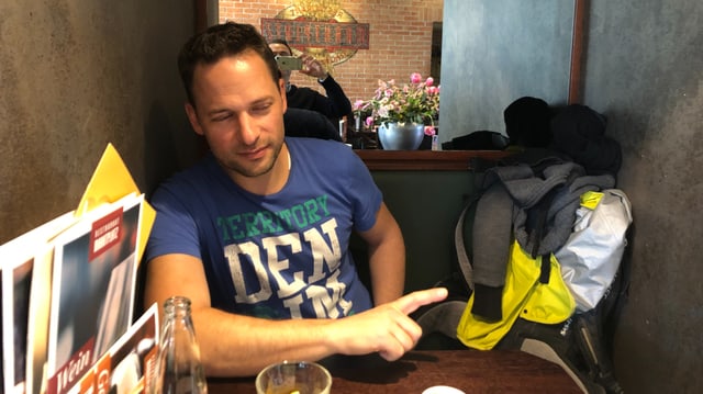 David Widmer in einem Restaurant an einem Tisch. 