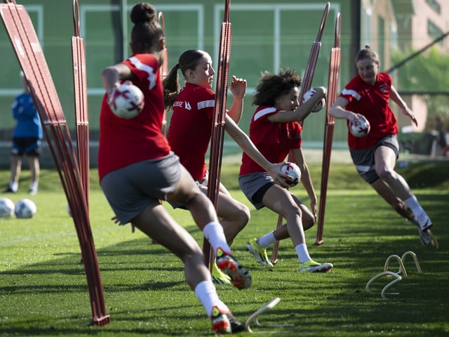 Spielerinnen überqueren im Training Hürden.