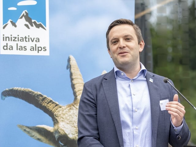 Pult vor einem Plakat der Alpenschutz-Initiative.