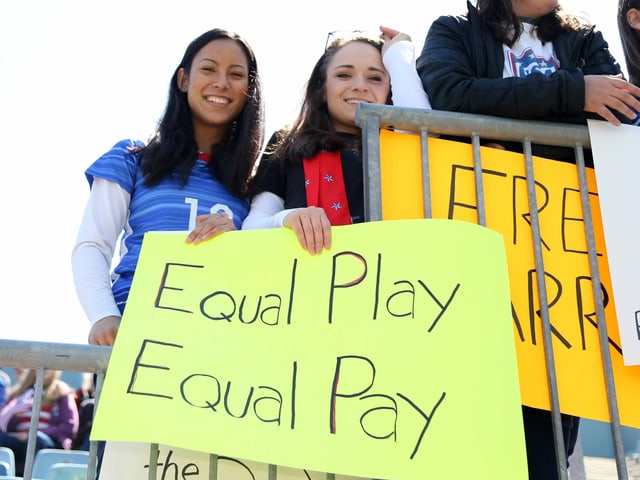 Two women hold a placard.