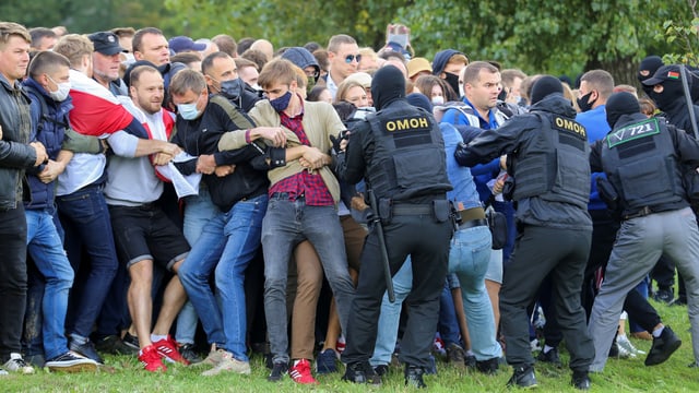 Demonstranten werden von Sicherheitskräften zurückgehalten.