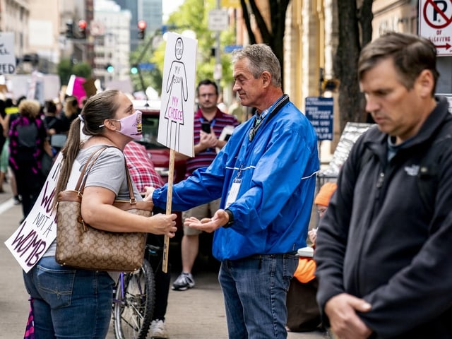 Eine Demonstrantin spricht einen Gegenprotestler an.