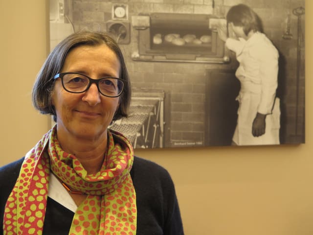 Frau vor Fotografie einer alten Bäckerei