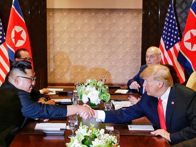 Trump und Kim am Tisch.