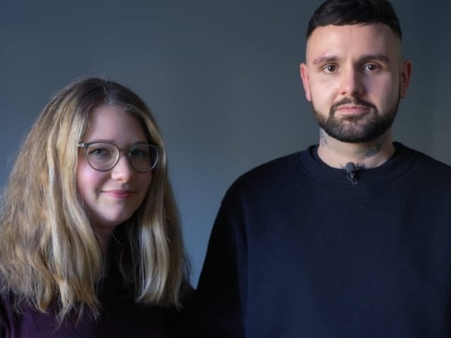 Frau mit blonden langen Haaren links und Mann mit kurzen Schwaren haaren und kurzem Bart link. Beide schauen freundlich.