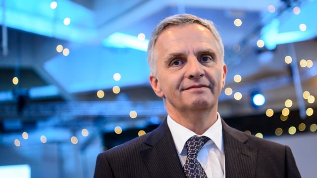 Burkhalter vor blauem Hintergrund mit kleinen Lämpchen, die leuchten.