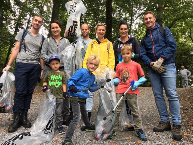 Gruppe von Leuten mit Abfallsäcken im Wald.