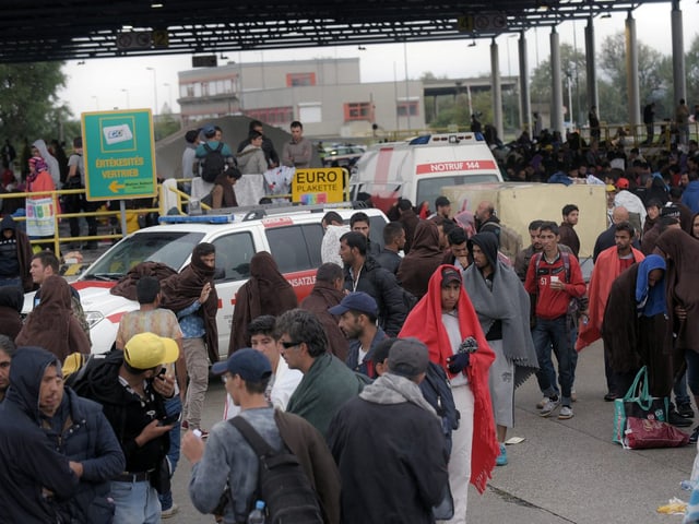 Flüchtlinge an einem Bahnhof in Österreich. 