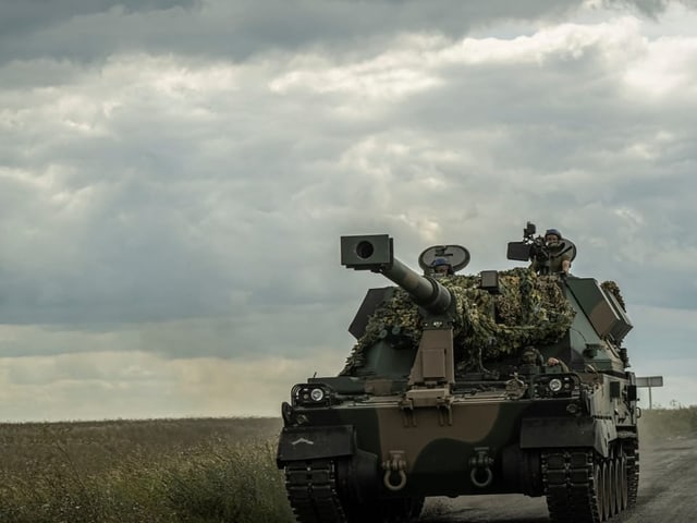 Ein Panzer fährt auf einem Feldweg.