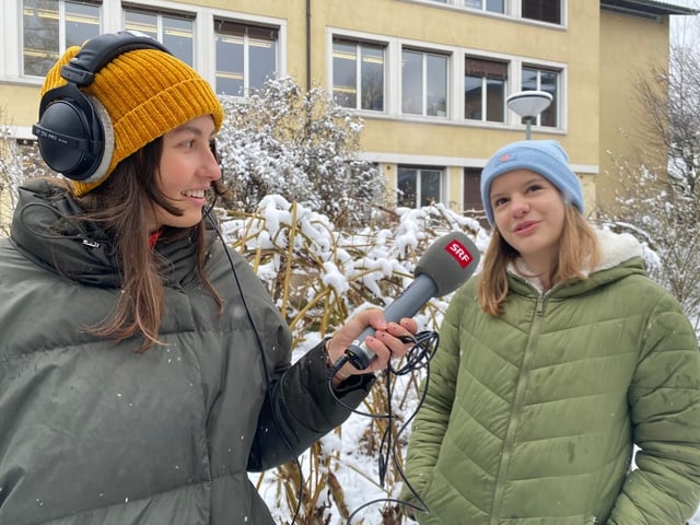 Mädchen spricht draussen in ein Mikrofon 