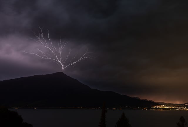 Blitz, der von Bergspitze in den Himmel geht.