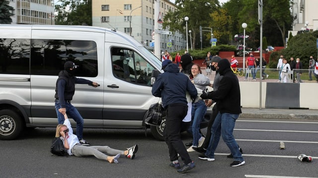 Protestierende werden weggetragen.