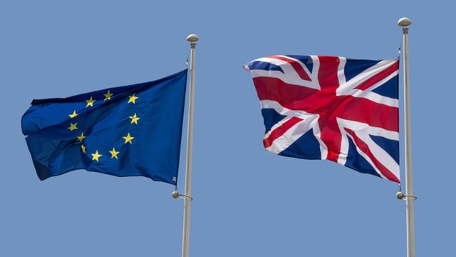 EU-Flagge und Grossbritannien-Flagge wehen im Wind.