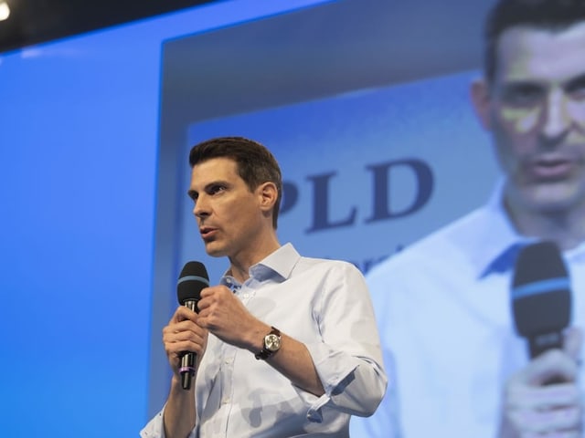 Thierry Burkart vor einer Leinwand mit FDP-Logo