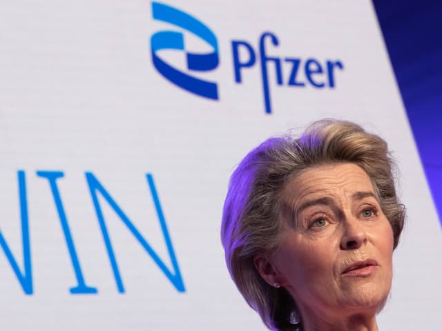 Frau spricht auf Veranstaltung vor Pfizer-Logo.