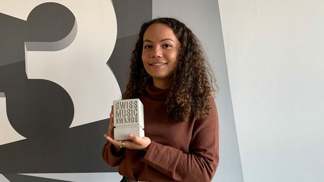 Caroline Alves hält einen Swiss Music Award in der Hand.