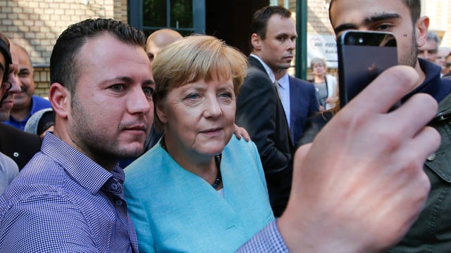 Ein Flüchtling macht ein Selfie mit Kanzlerin Angela Merkel 