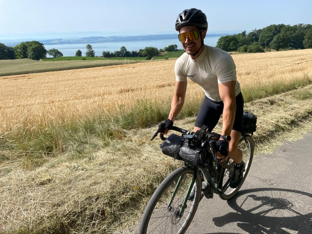 Auf dem Bild ist ein Biker am Neuenburgersee zu sehen.