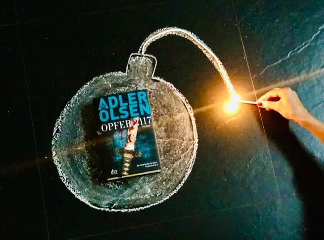 Jussi Adler-Olsens neuer Thriller «Opfer 2117» liegt in der Mitte einer gezeichneten Bombe, an deren Zündschnur ein Zündholz hingehalten wird