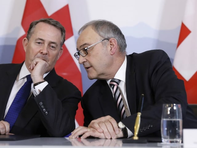 Guy Parmelin speaks with UK Minister for International Trade Liam Fox