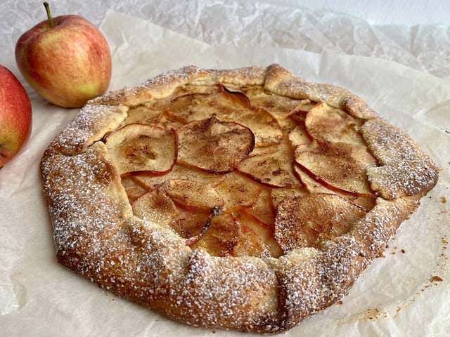 Apfelgalette und zwei Äpfel als Deko.