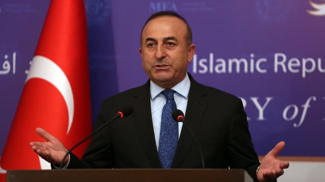 Cavusoglu bei einer Rede vor der türkischen Flagge