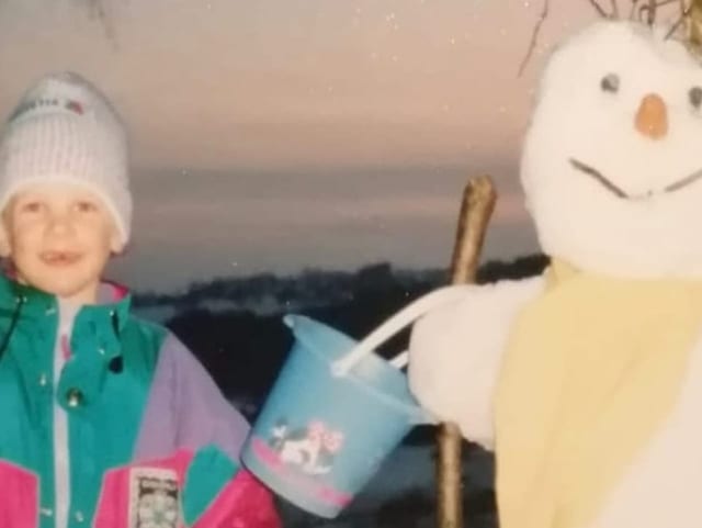 Auf der linken Seite steht Raphael als kleiner Junge, rechts ist ein Schneemann im Bild.